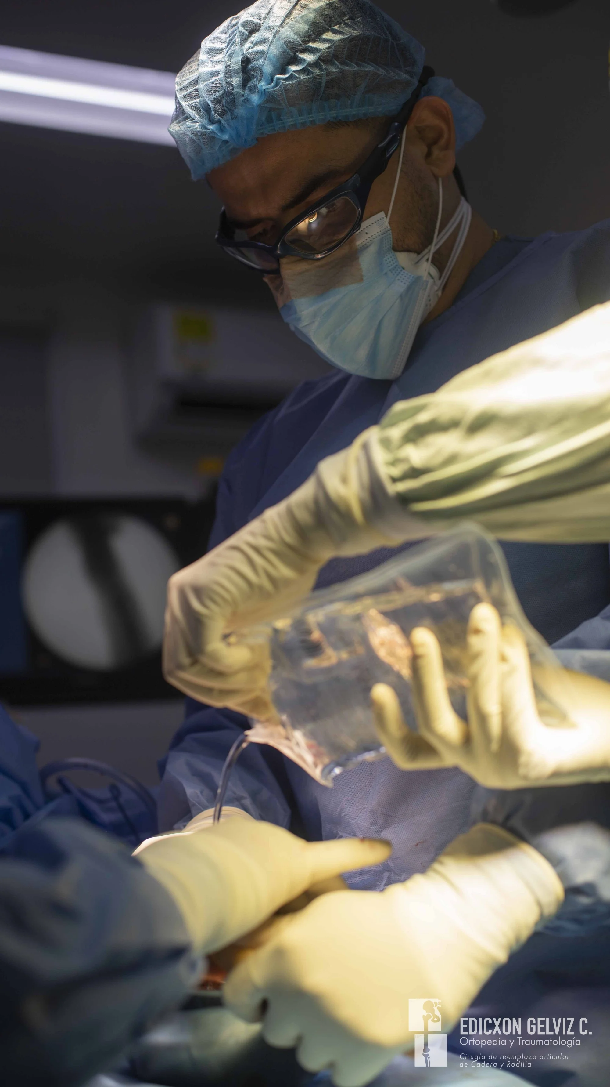 Dr. Edicxon Gelviz examinando componentes de prótesis de cadera antes de cirugía